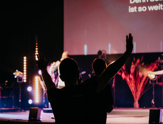 man in black t-shirt raising his hands