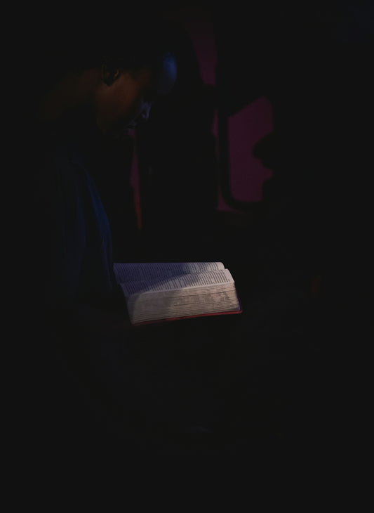 man in black shirt holding white paper
