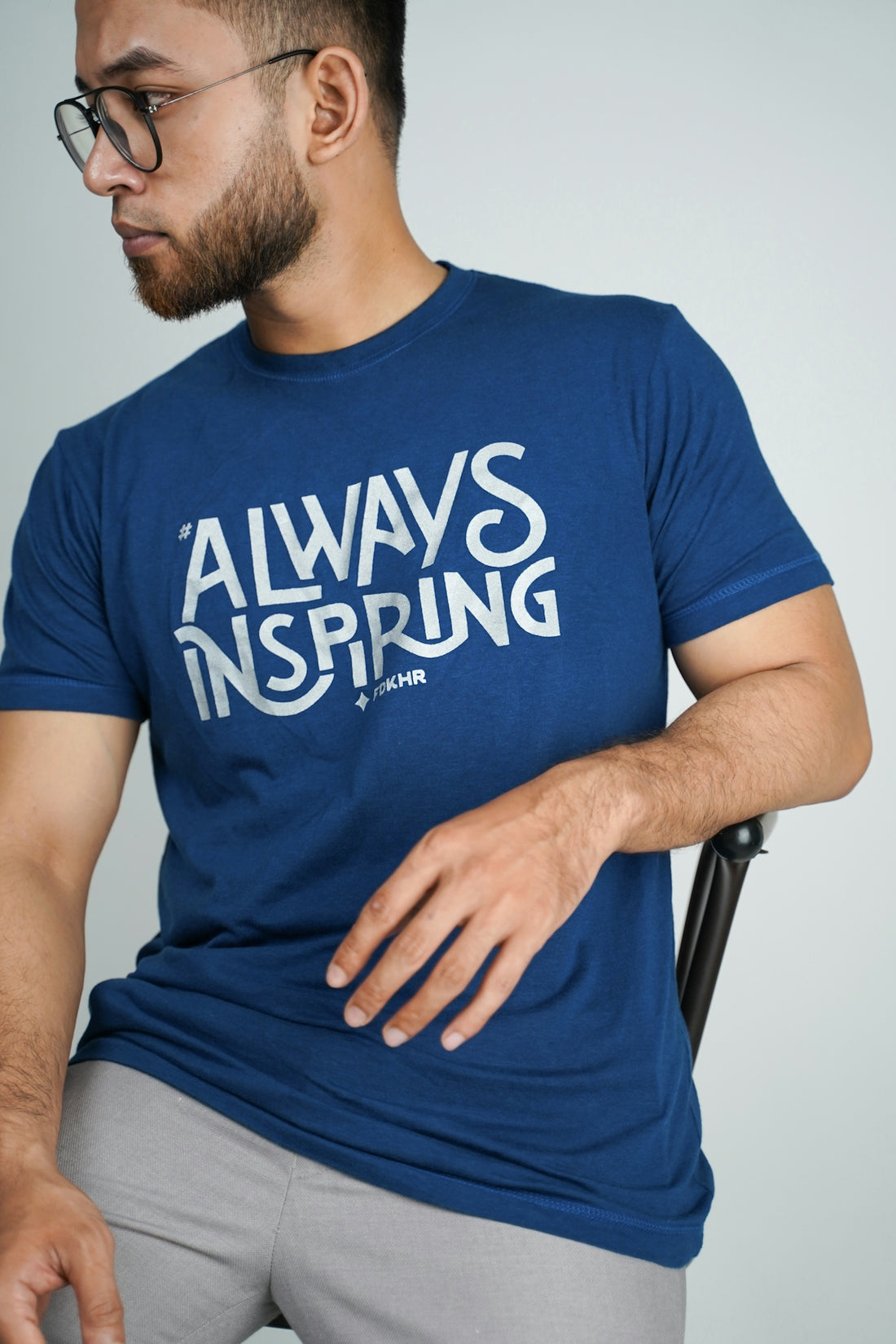 man in blue crew neck t-shirt sitting on black chair