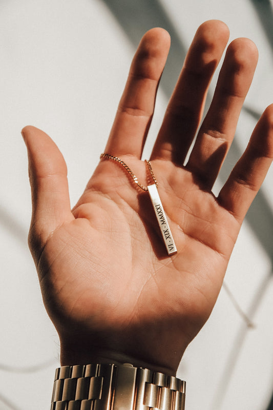 a person's hand with a gold bracelet on it