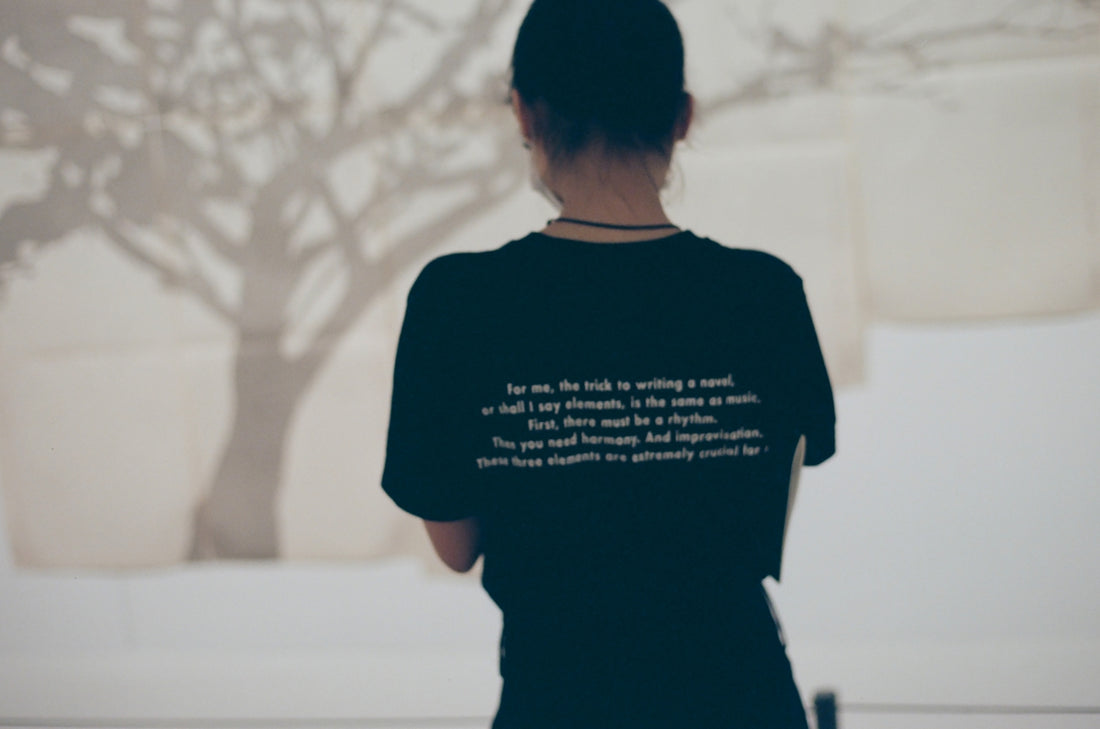 a woman standing in front of a tree with a quote on it