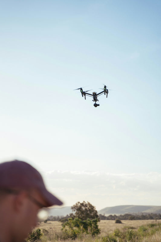 a man standing in a field looking at a flying object