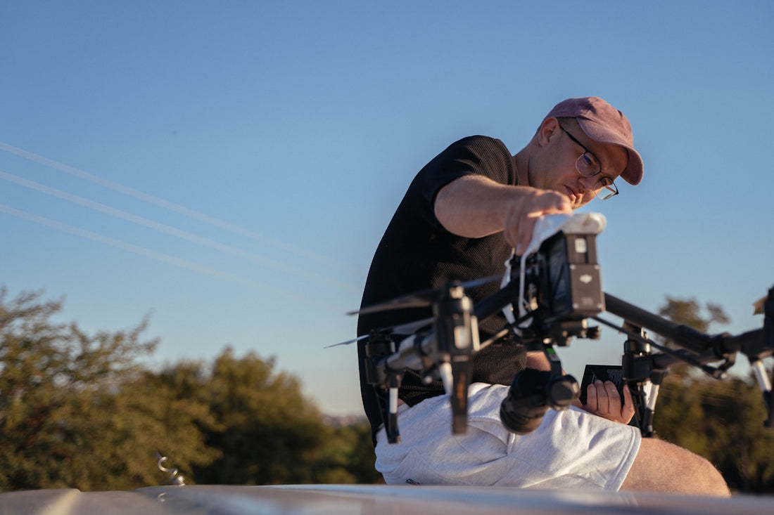 a man in a pink hat and glasses working on a camera