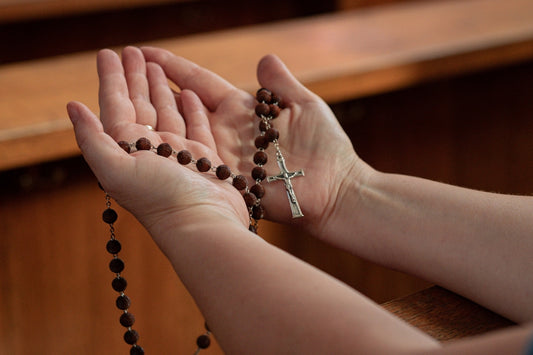 a woman holding a rosary in her hands