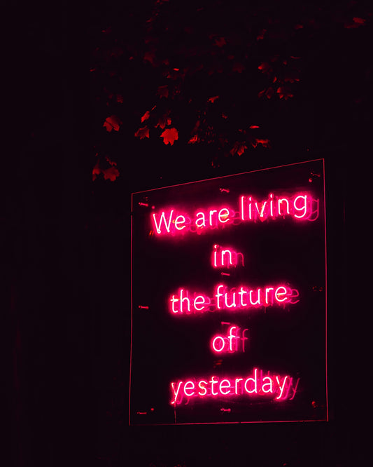 a neon sign that says we are living in the future of yesterday