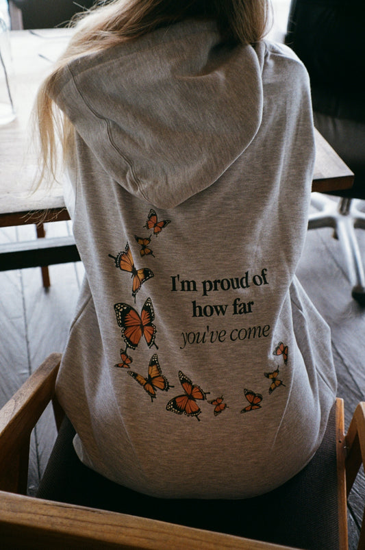 a woman sitting in a chair with a hoodie on