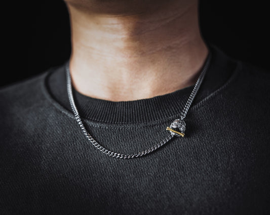 a man wearing a black shirt and a silver chain necklace