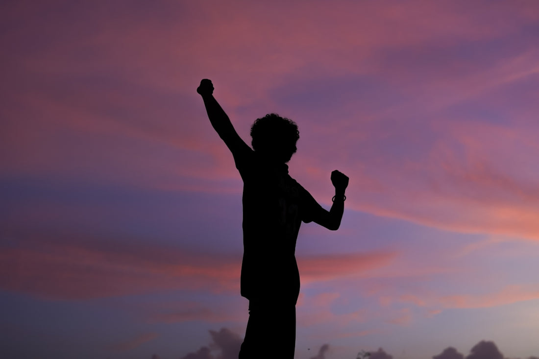 a man holding a cell phone up in the air
