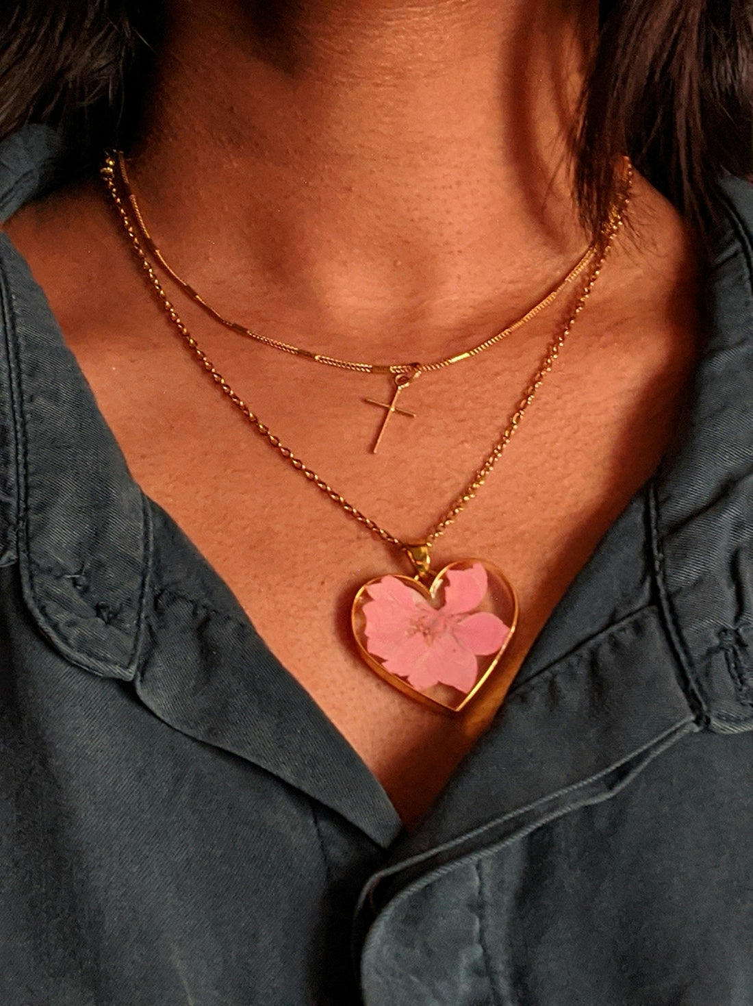 A close up of a person wearing a necklace with a heart on it