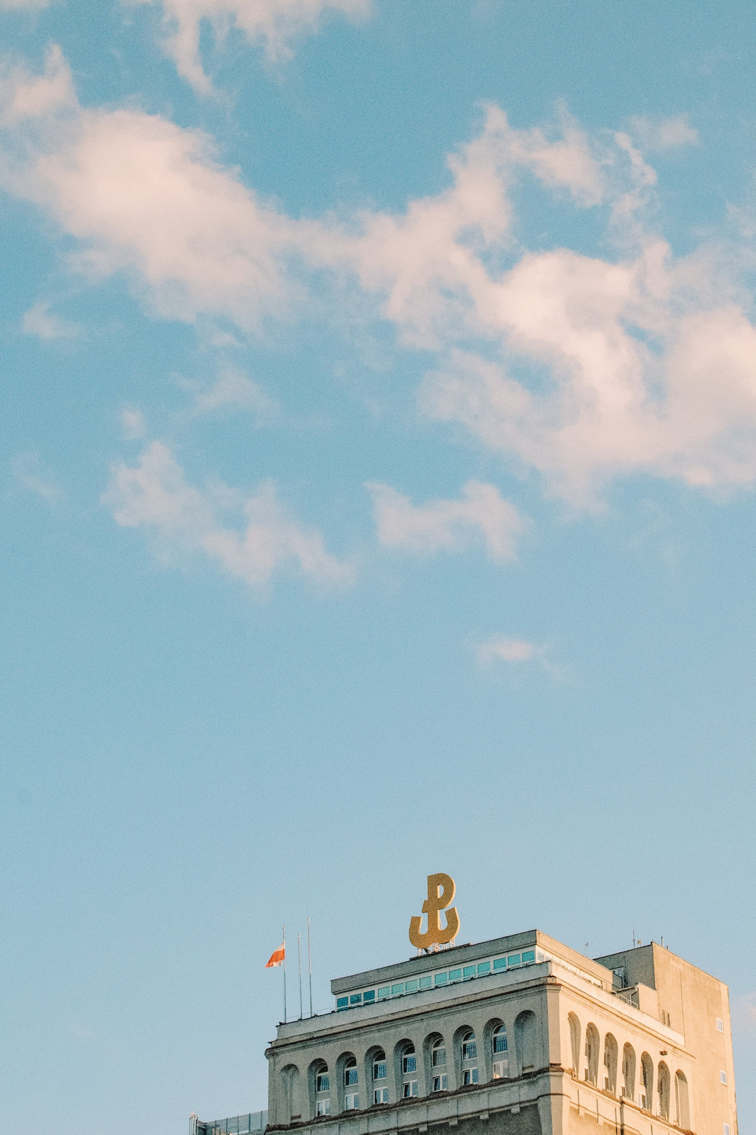 A building with a golden symbol against a blue sky.
