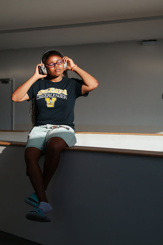 Young woman wearing headphones and glasses listens to music.