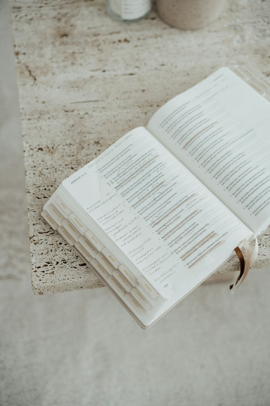 An open bible rests on a textured surface.