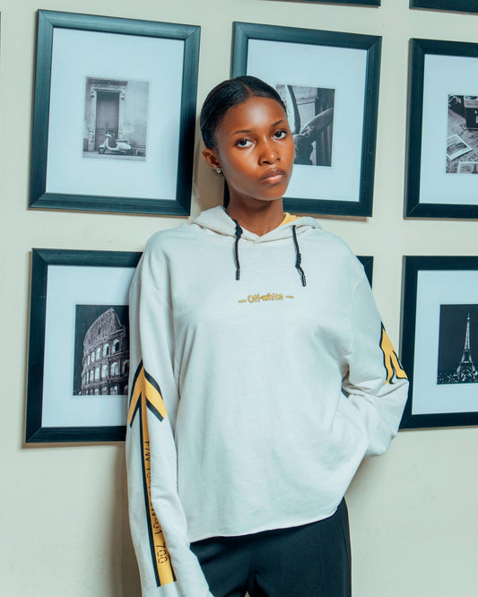 Young woman in hoodie stands against framed artwork