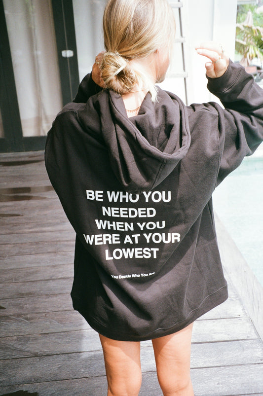 Woman wearing black hoodie with inspirational text.