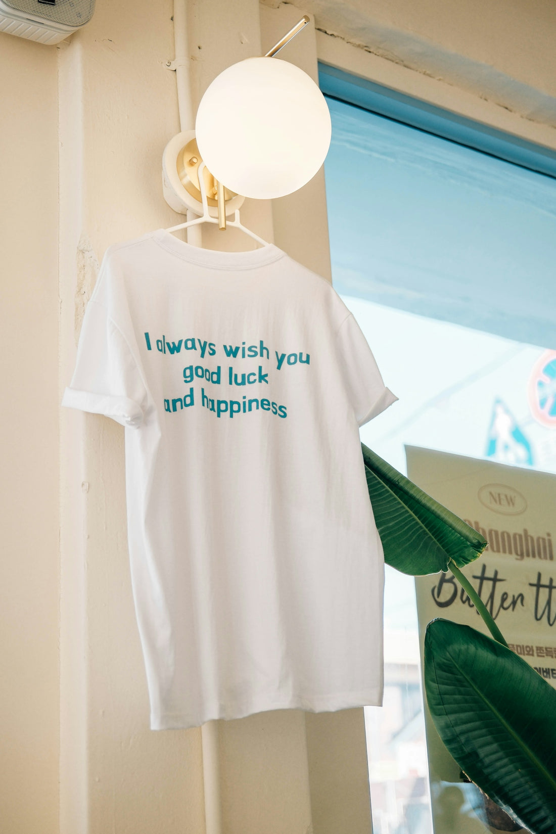 White t-shirt with blue text good luck and happiness